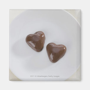 Geformte Pralinen des Herzens auf einer Platte Magnet