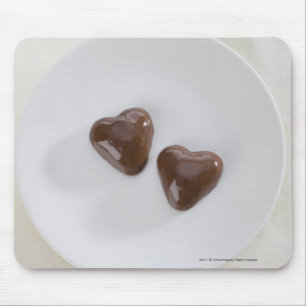 Geformte Pralinen des Herzens auf einer Platte Mousepad