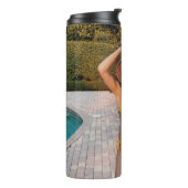 Gelbbikini-Frau stehend auf Braunziegelflur Thermosbecher (Nach links gedreht)