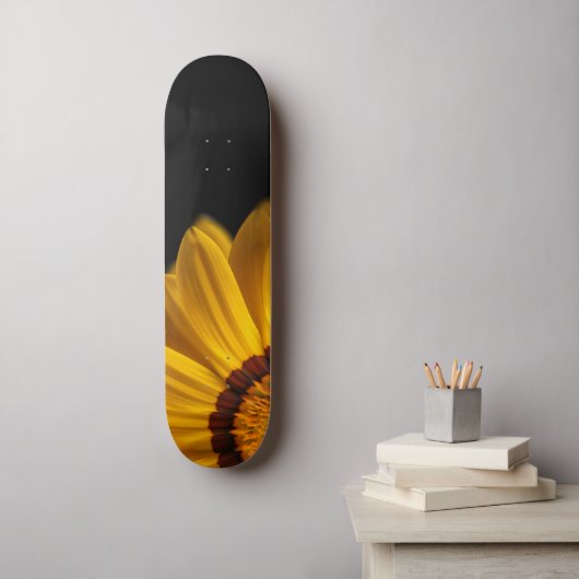 Gelbe Blume auf schwarzem Hintergrund Skateboard (Wandkunst)