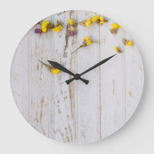 Gelbe Frühlingsblumen, weiße Putz. Große Wanduhr