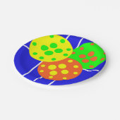 Gelbe, orangefarbene und grüne Pickleballs auf bla Pappteller (Schrägansicht)