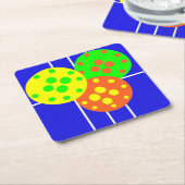 Gelbe, orangefarbene und grüne Pickleballs auf bla Rechteckiger Pappuntersetzer (angewinkelt)