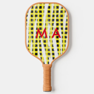 Gelbe schwarze Schachbrettmuster tragen den Namen  Pickleball Schläger