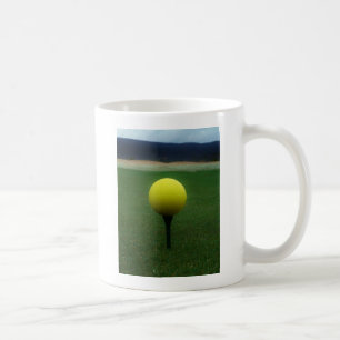 Gelber Golfball auf dem Golfplatz Kaffeetasse