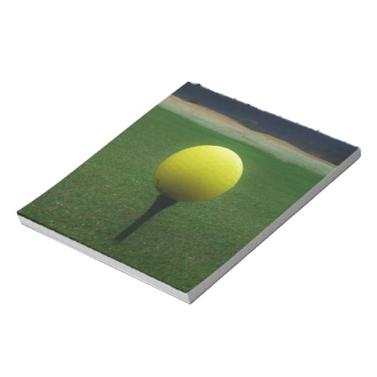 Gelber Golfball auf dem Golfplatz Notizblock (Rotiert)