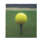 Gelber Golfball auf dem Golfplatz Notizblock (Vorderseite)