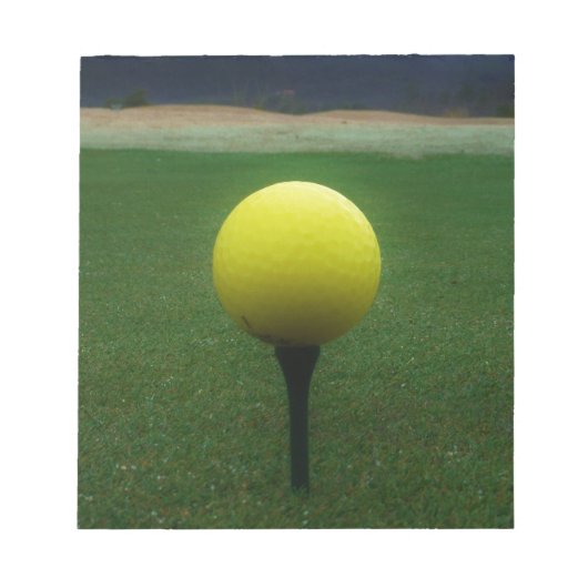 Gelber Golfball auf dem Golfplatz Notizblock (Vorderseite)