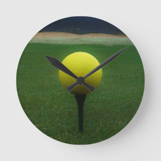 Gelber Golfball auf einem GebirgsGolfplatz Runde Wanduhr