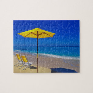 Gelber Strandsonnenschirm und Stühle auf makellose Puzzle