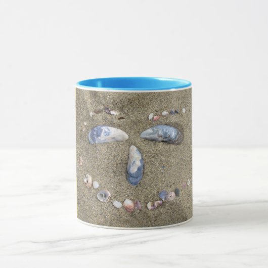 Gelbes Gesicht der Tasse gemacht im Sand mit (Zentrum)