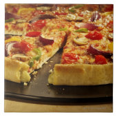 Gemüsepizza geschnitten auf schwarzer Wanne auf Fliese (Vorderseite)