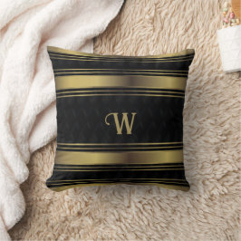 Geometrisches Monogramm aus schwarzen und goldenen Kissen