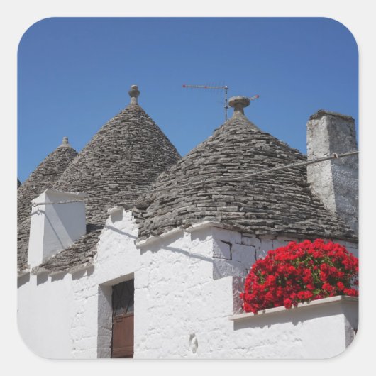 Geranium Blume und Trulli Häuser in Alberobello Quadratischer Aufkleber (Vorderseite)