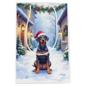 German Pinscher Snowy Courtyard Santa Hat Mittlere Geschenktüte (Vorderseite)