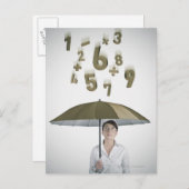 Geschäftsfrau unter einem Schirm mit Zahlen und Postkarte (Vorne/Hinten)