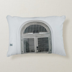 GESCHLOSSENE GARTENHOLZTÜR UNTER DER SCHWARZEN LIC DEKOKISSEN