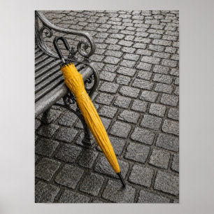 Geschlossener gelber Schirm neben Parkbank Poster