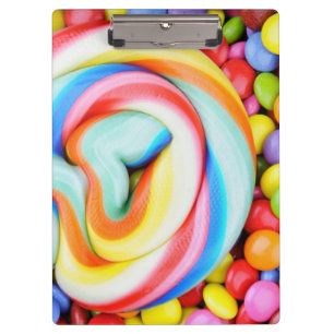 Gestreifter Lutscher und mehrfarbige Smarties Klemmbrett