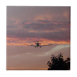 Gewerblicher Jet landet bei Sonnenuntergang Fliese