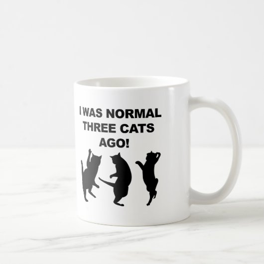 Gewöhnliche drei Katzen sind vor lustiger Umarmung Kaffeetasse (Rechts)