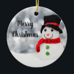 Ghear Snowman Ornament Round<br><div class="desc">Niedlicher Schneemann glitzert in der Sonne. Roter Scarf,  schwarzer Top Hut und grüne Knöpfe. Test lautet "Frohe Weihnachten"</div>