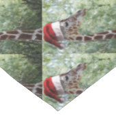 Giraffe mit einem Weihnachtshut auf Tischdecke (Schrägansicht)