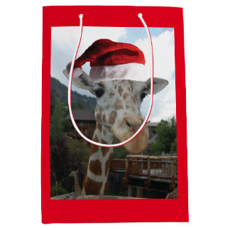 Giraffe mit einem Weihnachtshut zu Weihnachten Mittlere Geschenktüte