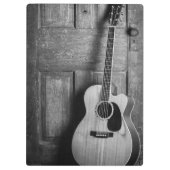 Gitarre lehnt gegen Tür in Schwarz und Weiß ab Klemmbrett (Rückseite)