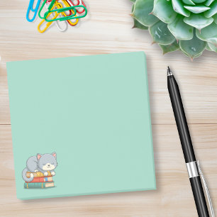 Glückliche Katze auf einem grünen Bücherstapel Post-it Klebezettel