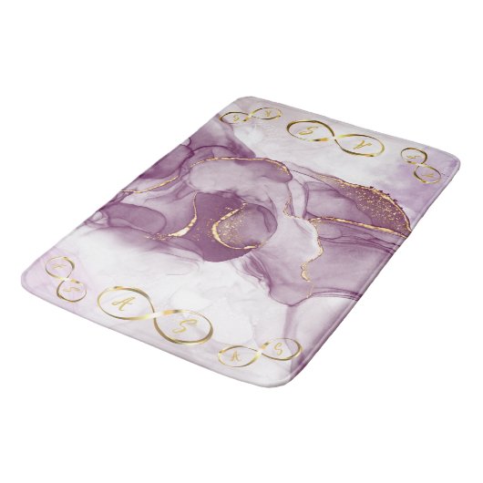 Gold Infinity Initial Monogram auf lila und gold Badematte (Schrägansicht)
