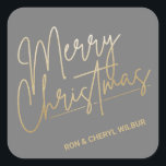 Gold Merry Christmas Luxe Gray Quadratischer Aufkleber<br><div class="desc">Frohe Weihnachten in einem Imitat Goldfolienskript und Ihre Namen in schicker Schrift,  diese grauen Aufkleber sind stilvoll für jeden Weihnachtsfeiertag. MEHR FARBEN und passende Produkte in unserer Kollektion.</div>