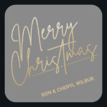 Gold Merry Christmas Luxe Gray Quadratischer Aufkleber<br><div class="desc">Frohe Weihnachten in einem Imitat Goldfolienskript und Ihre Namen in schicker Schrift,  diese grauen Aufkleber sind stilvoll für jeden Weihnachtsfeiertag. MEHR FARBEN und passende Produkte in unserer Kollektion.</div>