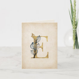 Gold- und schwarzes E-Monogramm mit Blättern