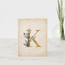 Gold- und schwarzes K-Monogramm mit Blättern