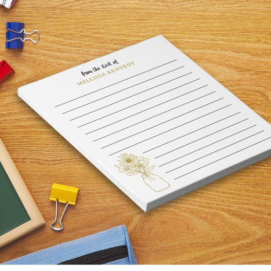 Gold und weiße Wildblume vom Schreibtisch der Notizblock