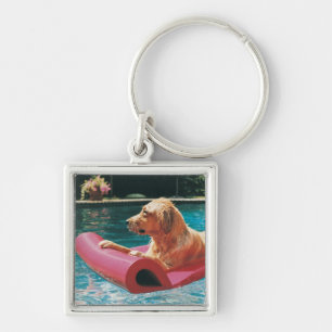 Golden retriever, das auf einem Luft-Bett in a Schlüsselanhänger