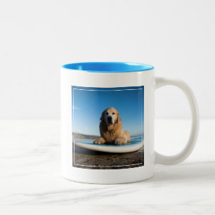 Golden retriever-Hund, der auf ein Paddel-Brett Zweifarbige Tasse