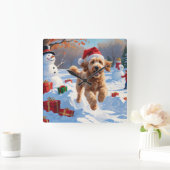 Goldendoodle läuft im Schnee mit Weihnachtshut Quadratische Wanduhr (Zuhause)