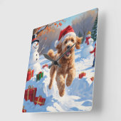 Goldendoodle läuft im Schnee mit Weihnachtshut Quadratische Wanduhr (Winkel)