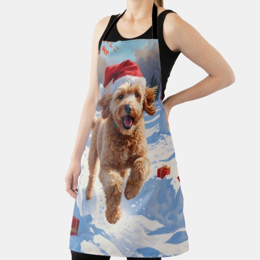 Goldendoodle läuft im Schnee mit Weihnachtshut Schürze (InSitu)