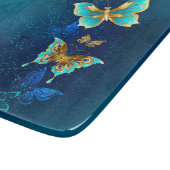 Goldene Schmetterlinge auf blauem Hintergrund Schneidebrett (Ecke)
