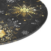 Goldene Schneeflocken auf schwarzem Hintergrund Schneidebrett (Ecke)