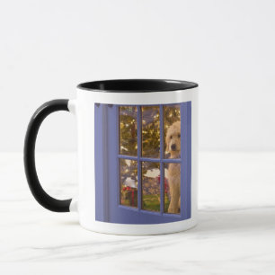 Goldener Gekritzelwelpe, der heraus Glastür mit Tasse
