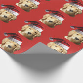 Goldener Retriever mit Weihnachtsmannmütze auf Geschenkpapier (Ecke)