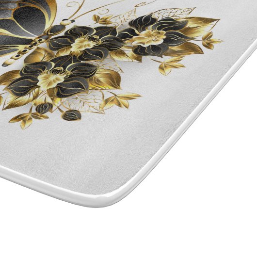 Goldener Schmetterling mit schwarzem Orchid Schneidebrett (Ecke)
