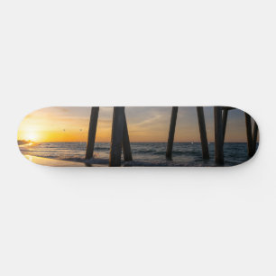 Goldener Sonnenaufgang unter dem Pier von Pensacol Skateboard