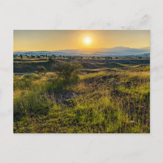 Goldener Sonnenuntergang über üppigem Wald Feiertagspostkarte