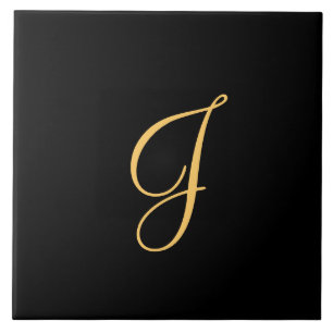 Goldfarbener Erstling J auf schwarzem Hintergrund Fliese