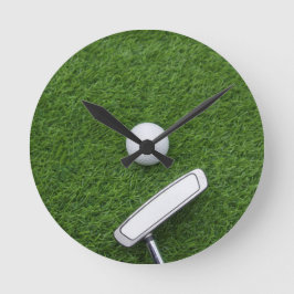 Golfball mit Putter sind auf grünem Gras Runde Wanduhr